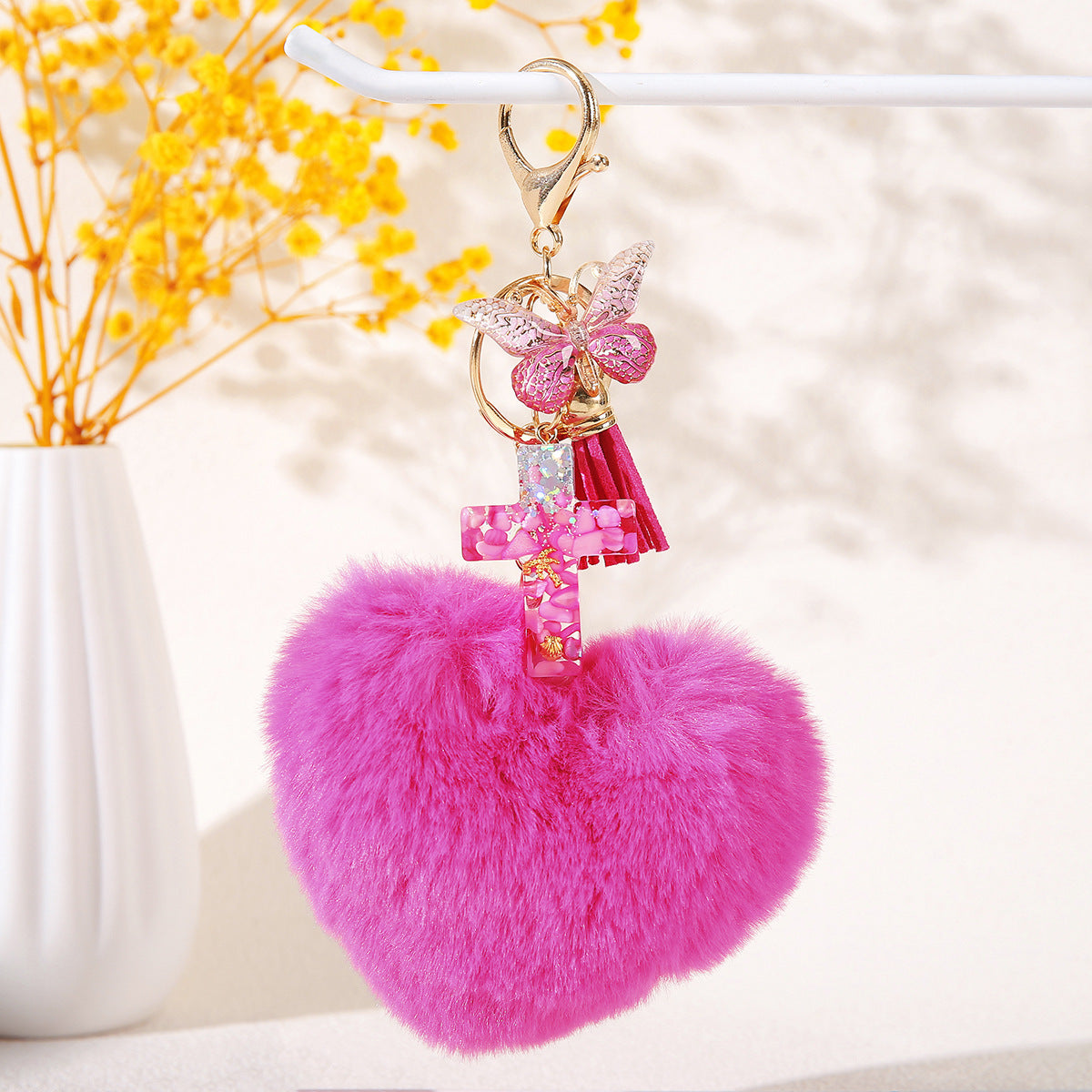 Wholesale Resin butterfly cross keychain with heart-shaped pom-pom